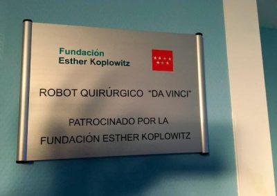 Placa del Robot Da Vinci con los logos de la Fundación Esther Koplowitz y la Comunidad de Madrid, acompañada del texto: 'Robot Quirúrgico "Da Vinci" Patrocinado por la Fundación Esther Koplowitz