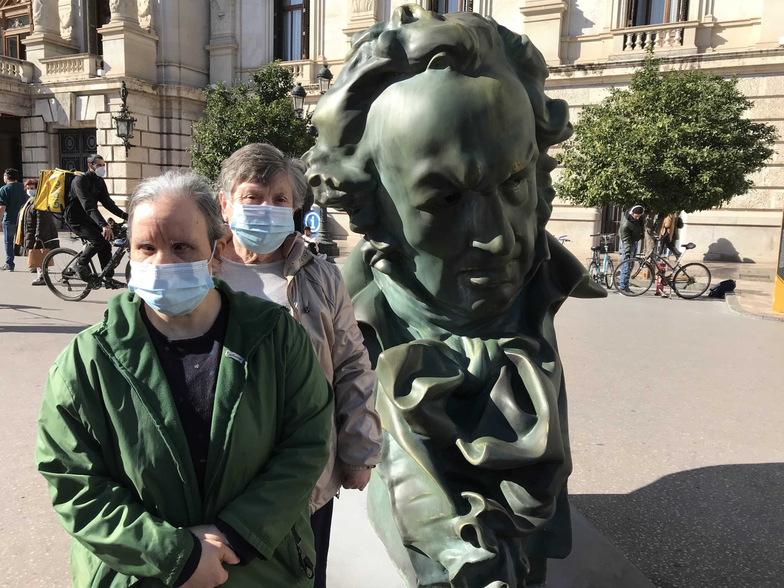 Residentes de Nostra Casa Vall de la Ballestera posando junto a una estatua grande de una figura importante de los Premios Goya