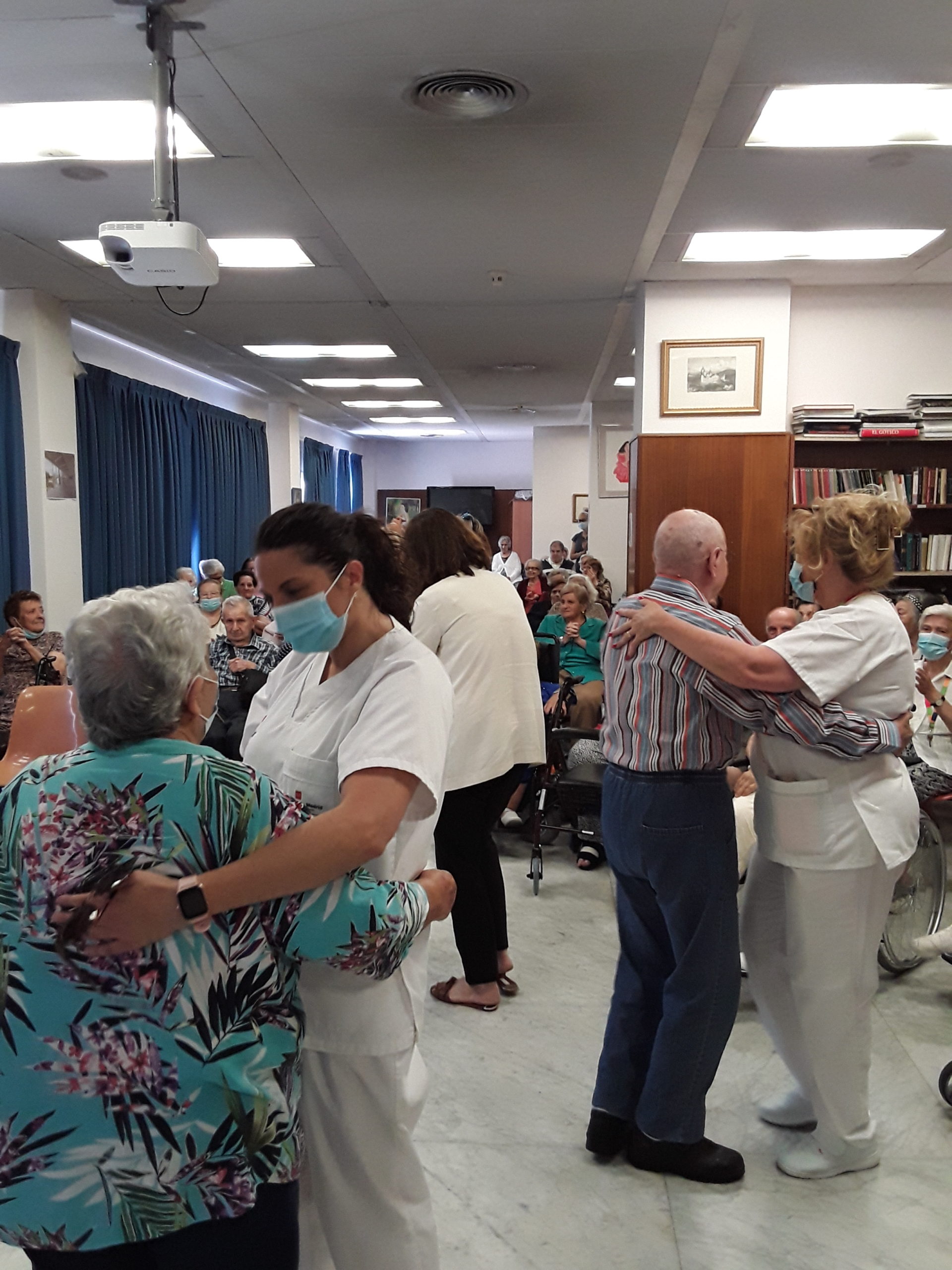 Residentes bailando con su cuidadora durante la actuación de Carmen Mora en la Residencia Nuestra Casa de Collado Villalba