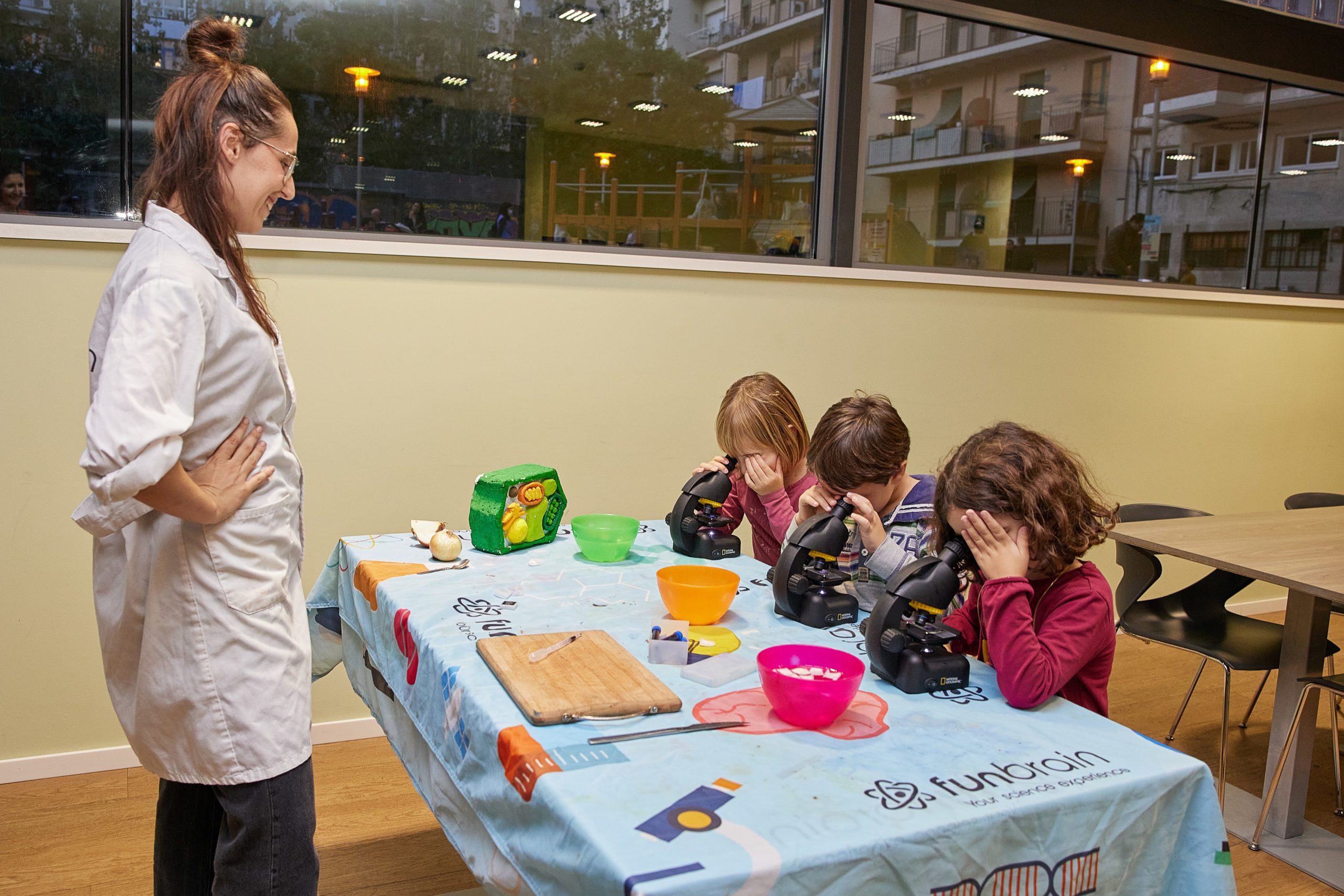 Niños pequeños observando a través de microscopios con la guía del equipo del Centro Esther Koplowitz