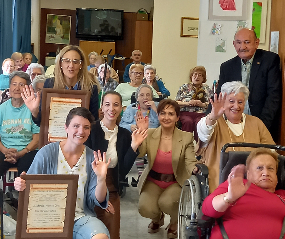 Vanesa Triviño Alonso y Arancha Hervás sonríen junto a los residentes después de la charla en la residencia Nuestra Casa de Collado Villalba