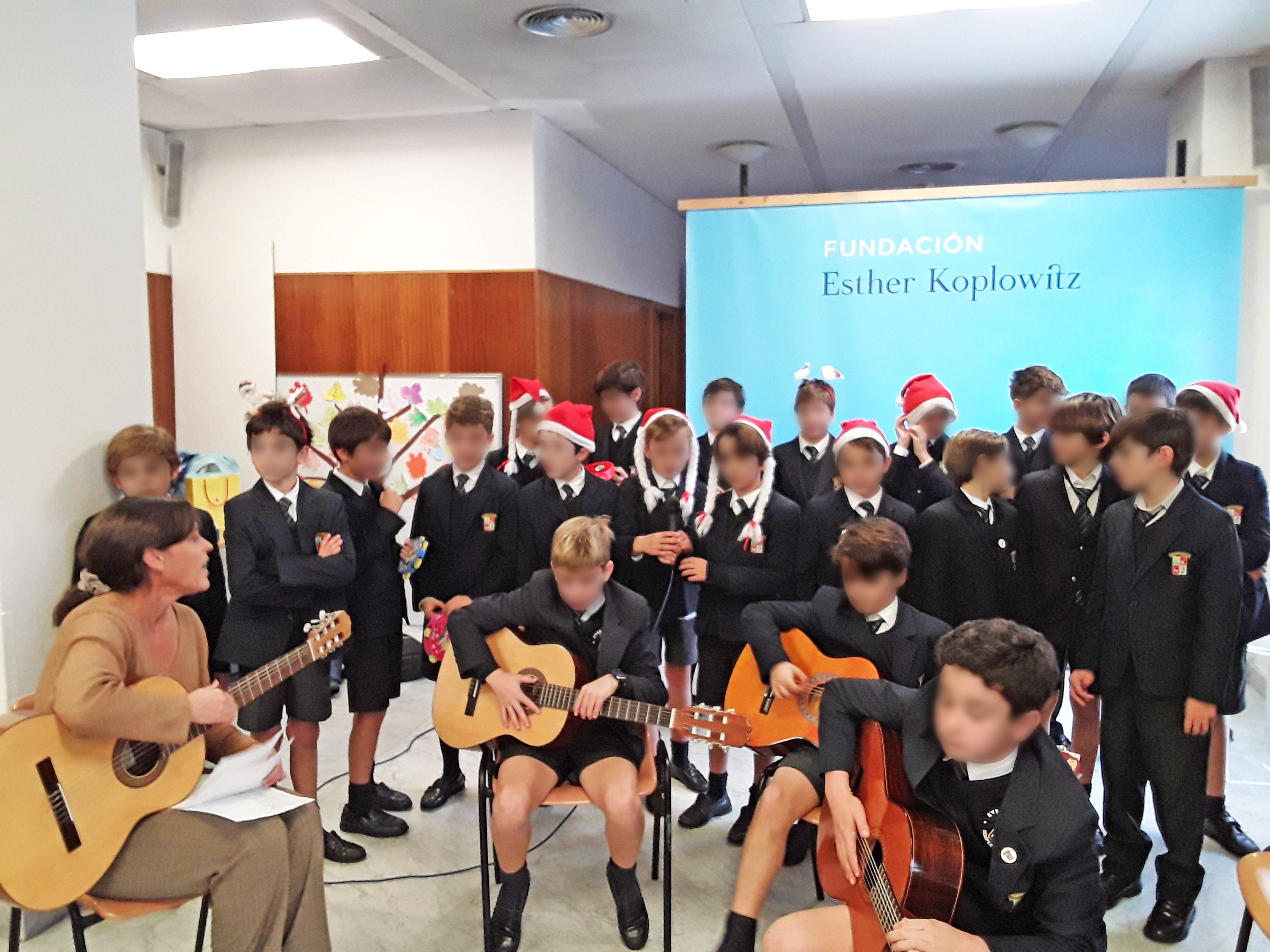 Los alumnos del Colegio Everest School, algunos tocando guitarras y otros cantando, ofreciendo una actuación para los residentes de la residencia Nuestra Casa de Collado Villalba