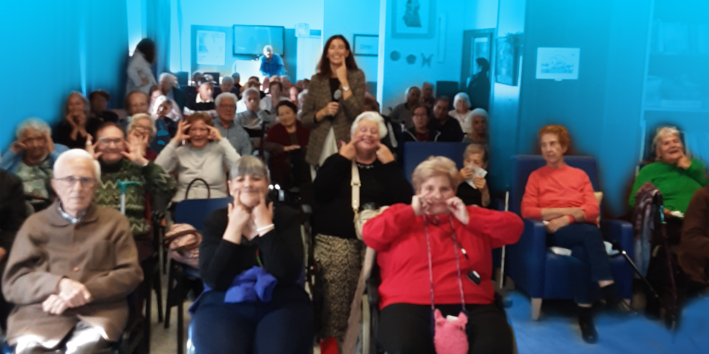 Doctora Almudena Martínez Bravo junto a los residentes sonrientes, señalando con los dedos hacia sus sonrisas